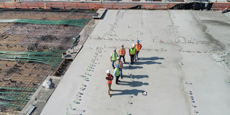 7 men on site wearing hard hats and hi-vis vests